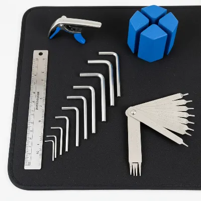 Assortment of essential tools for electric guitar truss rod adjustment, including hex keys, feeler gauges, and a capo.